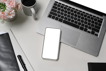 Mock up mart phone, laptop computer and coffee cup on white office desk.