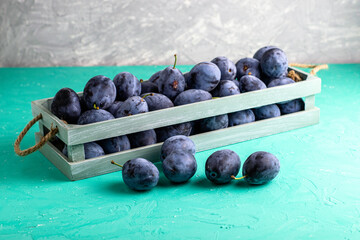 freshly picked ripe plums in a vintage box several plums are lying next to each other on the table