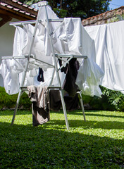white bedding, clothesline drying, hanging outside. 