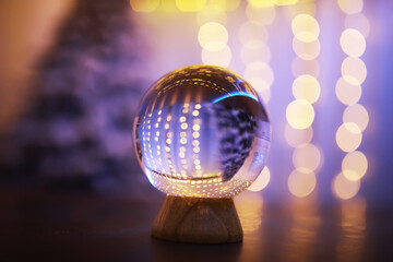 Fototapeta na wymiar Crystal Ball on the floor with bokeh, lights behind. Glass ball with colorful bokeh light, new year celebration concept.