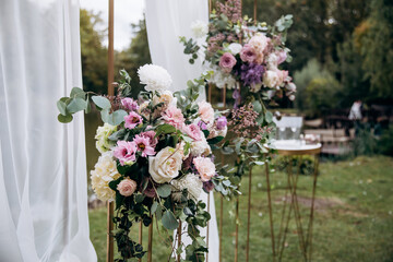 Decorating the arch with flowers and fabric for a wedding ceremony in nature - 460750305