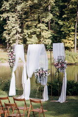 Decorating the arch with flowers and fabric for a wedding ceremony in nature - 460750320