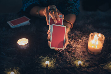 Fortune teller holding tarot cards. tarot cards and burning candles. Astrologists and forecasting concept. - obrazy, fototapety, plakaty