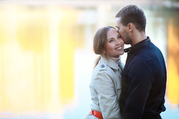 A man and a girl in love on a first date in an autumn city park.