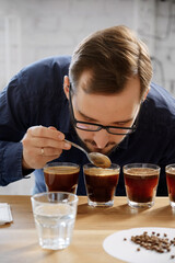 Man smelling freshly ground coffee in cup