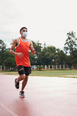 Obraz premium young latin athlete with protective mask running on warm-up track