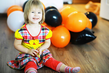 Portrait of a small child lying on the floor in a room decorated with balloons. Happy childhood concept.