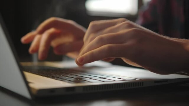 Laptop typing, male hands keyboard. Office work in the evening. Close-up, no face in the frame. Programming, information analysis. The student is studying, writing a project. Desktop, space for work.