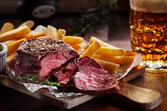Tasty beef steak slices with French fries and beer