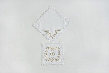 White embroidered wedding towels on a white background.