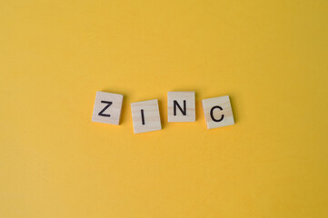 Square letters with text ZINC isolated on a yellow background