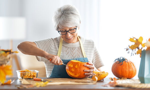 woman is carving pumpkin
