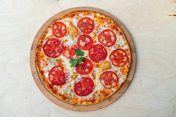 Tasty margarita pizza on a wooden background.