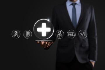 Businessman hold virtual plus medical network connection icons. Covid-19 pandemic develop people awareness and spread attention on their healthcare.Doctor,document,medicine,ambulance,patient icon.