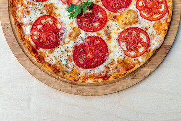 Tasty margarita pizza on a wooden background.