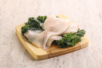 Raw squid over wooden board