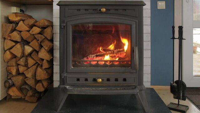 Close-up view of burning fireplace with wooden logs and flames inside
