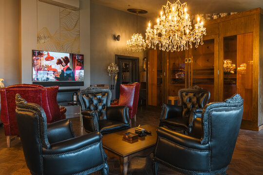 Moscow, Russia, 06.07.2021, Luxurious cigar room interior with large leather armchairs and chandeliers