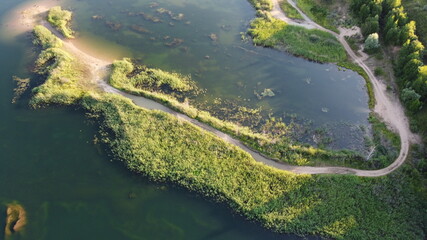 Flooded and overgrown sand quarry. Lush green summer landscape for outdoors vacation, hiking, camping or tourism. Volokolamsk district of Moscow region. Sychevo beach, Russia