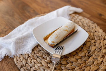 Beautiful delicious eclairs on the table in a plate. Delicious pastries close-up. Table setting