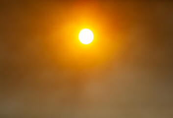 The sun in the sky in the smoke from the fire.