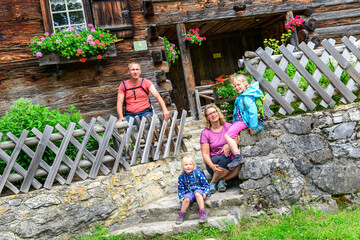 Familie posiert vor einem historischen Bauernhaus im Allgäu