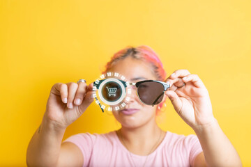young woman showing smart glasses with futuristic hologram and shopping cart icon