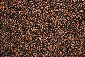 Roasted coffee beans spilled freely on a wooden table. Coffee beans background. Coffee break