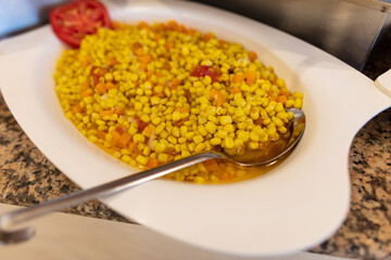 A platter of corn with vegetables in a restaurant.