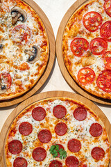 Delicious italian pizzas served on wooden table.