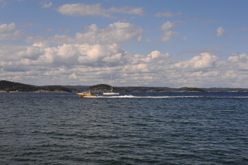 Fototapeta premium Sea landscape with clouds and yachts on a sunny summer day near Jomfruland island in Norway