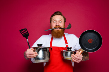 scared chef with beard and red apron is ready to cook