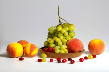 Fruits-grapes, peach, dogwood berries on a milky white background and gray background, close-up.