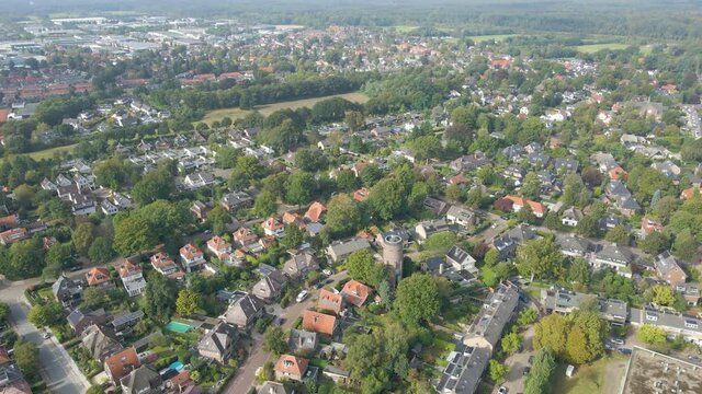 aerial of monumental water tower standing in a suburban neighborhood