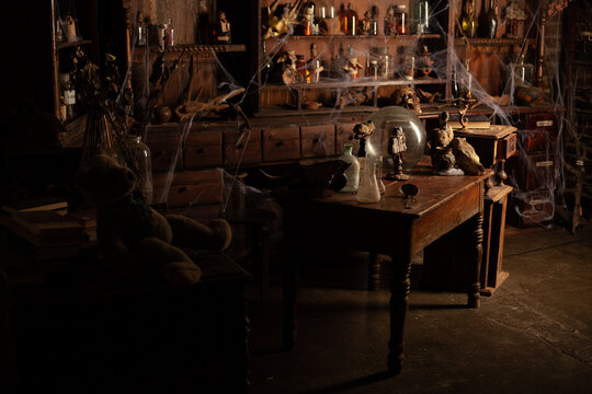 Halloween background Shelves with alchemy tools Skull spiderweb bottle with poison candles