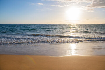 Fototapeta na wymiar Sunset. Beach background. Calm beautiful ocean wave on sandy beach. Sea view from tropical sea beach.