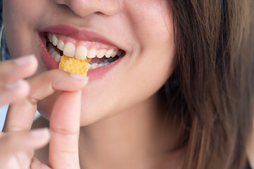 Woman mouth eating potato chips or crispy fried potato, health and medical concept of unhealthy food, high sodium and saturated fat fried food, unhealthy lifestyle, bad breath, oral care