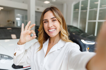 Close up woman customer buyer client in white shirt do selfie shot pov mobile phone show ok gesture...