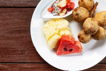 Mixed fruit plate on white brown table