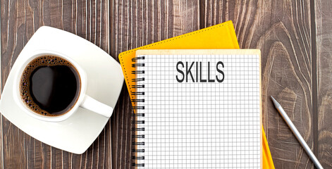 SKILLS text on the notebook with coffee on wooden background