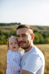 dad hugs baby on a background of nature on a summer day