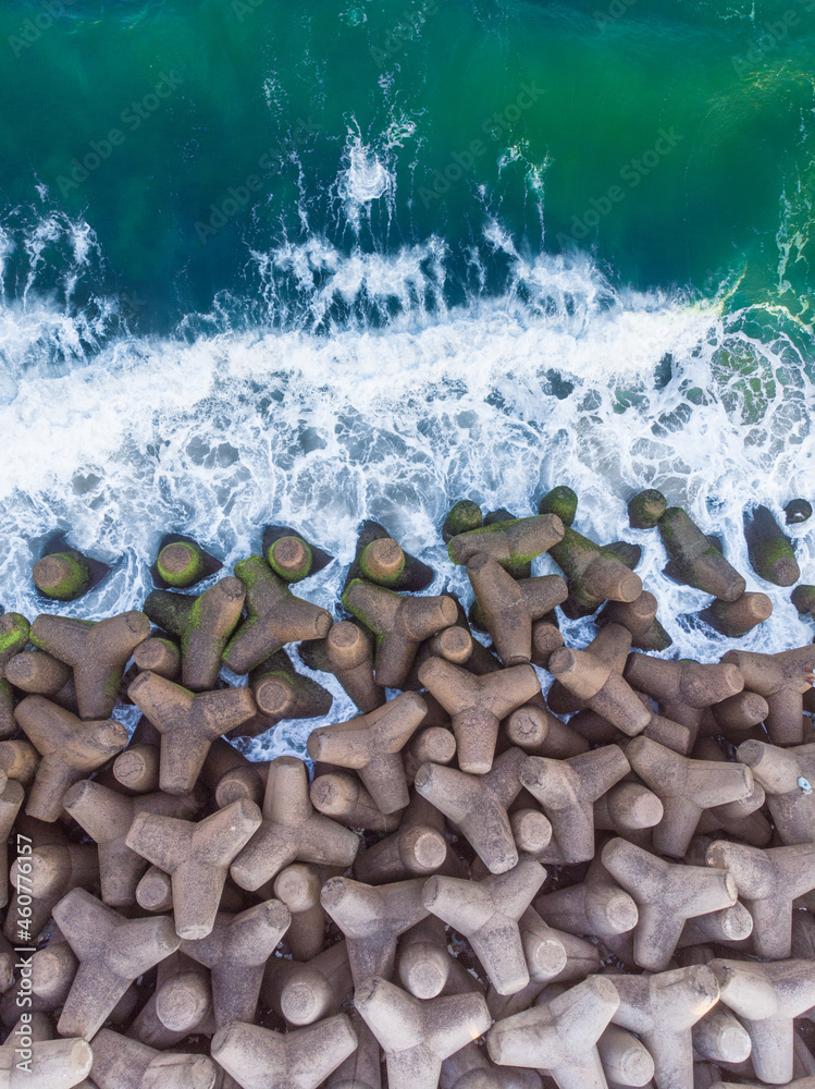 Sticker Top view shot of tetrapods at the edge of the sea