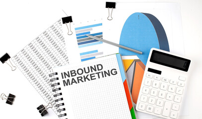 Text INBOUND MARKETING on a notebook on the diagram and charts with calculator and pen