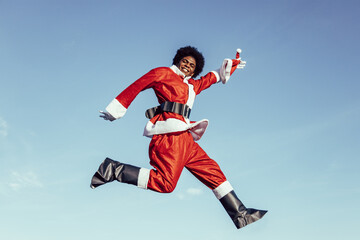 Black afro santa claus jumping with excitement and smiling to the camera