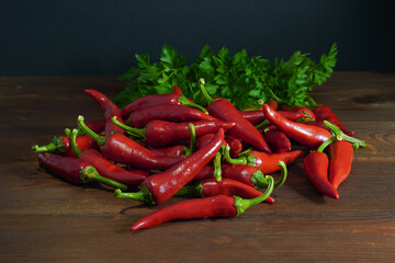 Red chili peppers and parsley on wooden table