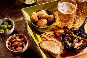 Assorted snacks and glasses of beer on table
