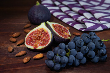 Fresh figs with grapes and almonds on a wooden table