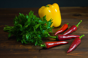 Red chili peppers bulgarian pepper and parsley on wooden table