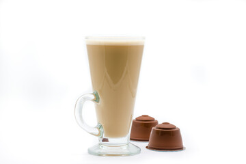 A tall glass of coffee latte or cappuccino and generic coffee pods that will fit many commercially available machines