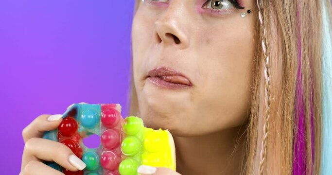 Portrait of an attractive girl eating gelatinous antistress.